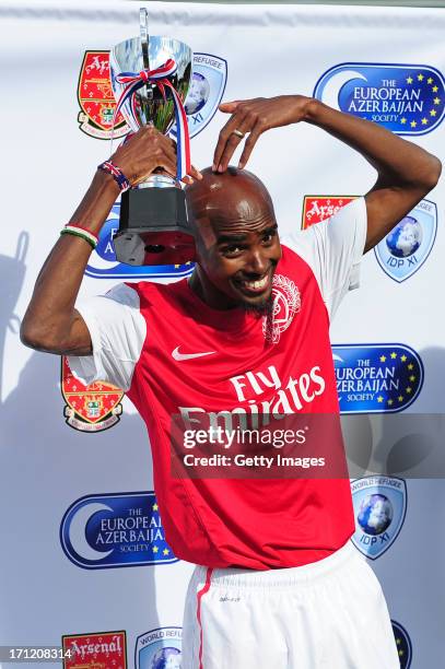 Mo Farah, manager of Arsenal Legends XI poses with the winners trophy after the charity football match between Arsenal Legends XI and World Refugee...