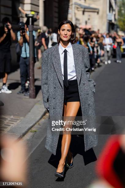 Alex Riviere wears grey coat, black shorts, tie, white button shirt outside Valentino during the Womenswear Spring/Summer 2024 as part of Paris...