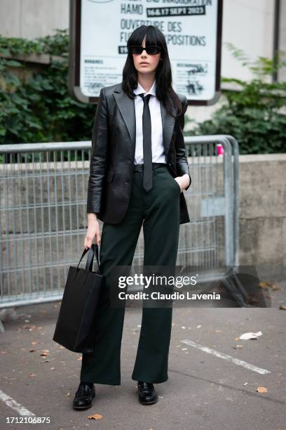 Shawna Kirkham wears a black leather tote bag, black leather blazer, white shirt with black tie, green trousers, outside Leonard Paris, during the...