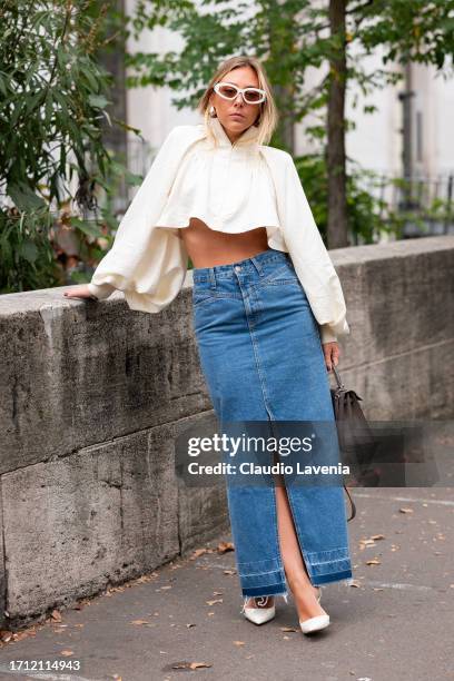 Guest wears a white puff sleeves top, long denim skirt and taupe bag, outside Leonard Paris, during the Womenswear Spring/Summer 2024 as part of...