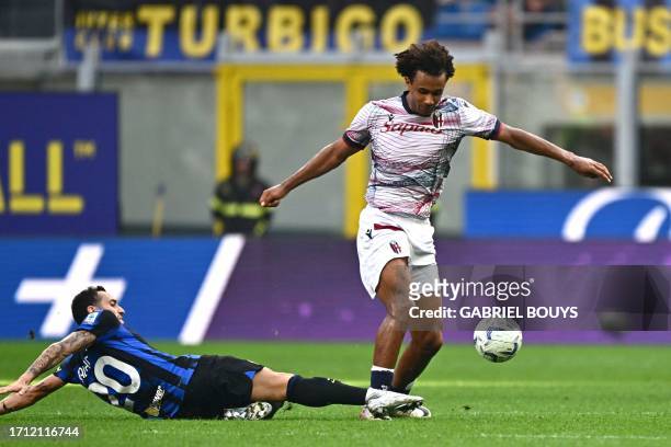 Inter Milan's Turkish midfielder Hakan Calhanoglu and Bologna's Dutch forward Joshua Zirkzee fight for the ball during the Italian Serie A football...