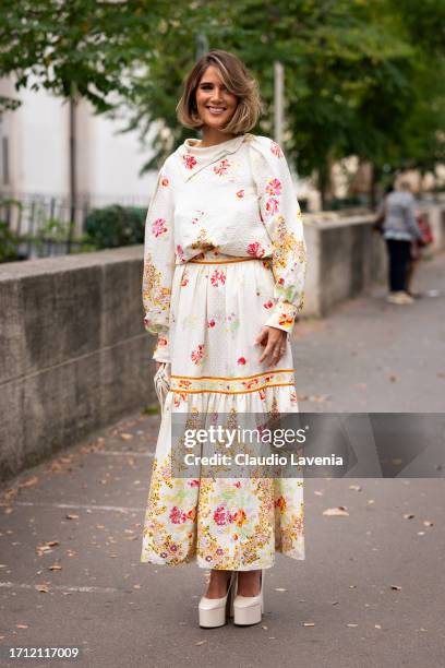 Guest wears a cream flower print top with matching maxi skirt and cream platform heels, outside Leonard Paris, during the Womenswear Spring/Summer...