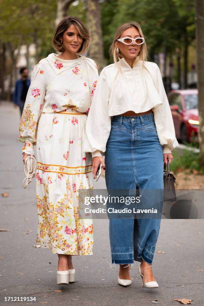 Guests wear a cream flower print top with matching maxi skirt and cream platform heels and cream blouse and long denim skirt , outside Leonard Paris,...