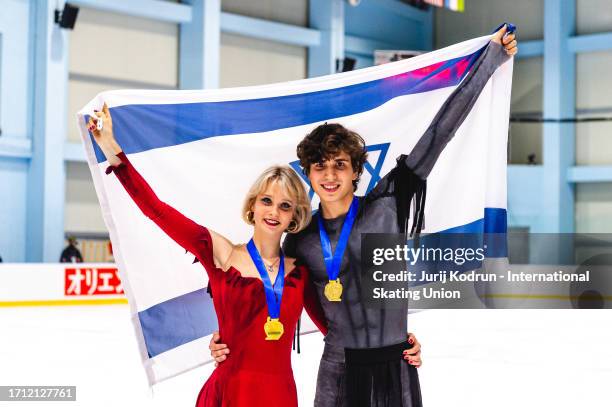 Gold medal winners Elizabeth Tkachenko and Alexei Kiliakov of Israel pose with flags after medal ceremony during the ISU Junior Grand Prix of Figure...