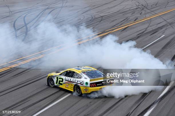Ryan Blaney, driver of the Menards/Pennzoil Ford, celebrates with a burnout after winning the NASCAR Cup Series YellaWood 500 at Talladega...