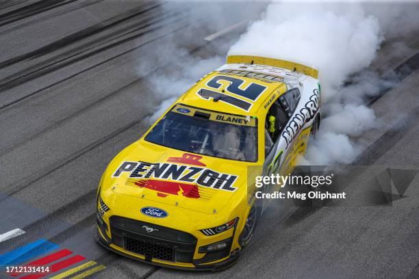 Ryan Blaney, driver of the Menards/Pennzoil Ford, celebrates with a burnout after winning the NASCAR Cup Series YellaWood 500 at Talladega...