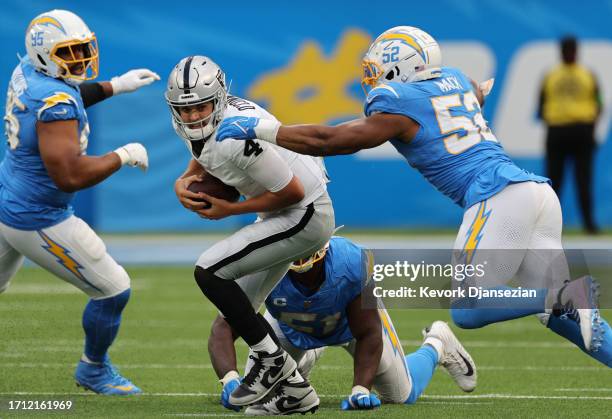 Aidan O'Connell of the Las Vegas Raiders is pressured by Sebastian Joseph-Day and Khalil Mack of the Los Angeles Chargers during the third quarter at...