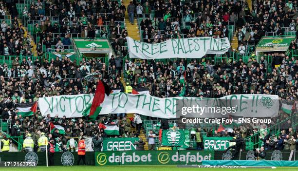 The Green Brigade hold up a banner for Palestine during a cinch Premiership match between Celtic and Kilmarnock at Celtic Park, on October 07 in...