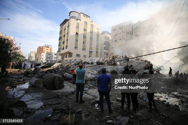 People assess the destruction cause by Israeli air strikes in Gaza City on October 7, 2023. Palestinian militants have begun a ''war'' against Israel...