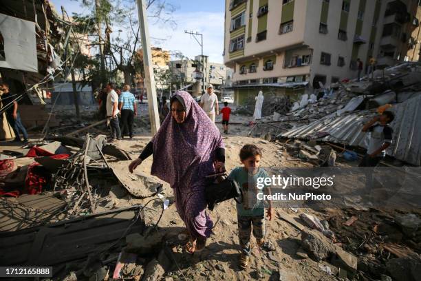 People assess the destruction cause by Israeli air strikes in Gaza City on October 7, 2023. Palestinian militants have begun a ''war'' against Israel...