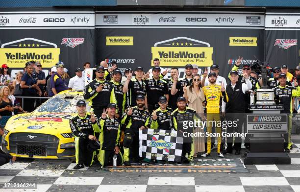 Ryan Blaney, driver of the Menards/Pennzoil Ford, celebrates with his crew, team owner, Roger Penske and Gianna Tulio in victory lane after winning...