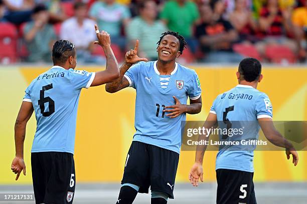 Abel Hernandez of Uruguay celebrates with teammates Alvaro Pereira and Walter Gargano after scoring in the 2nd minute against Tahiti during the FIFA...