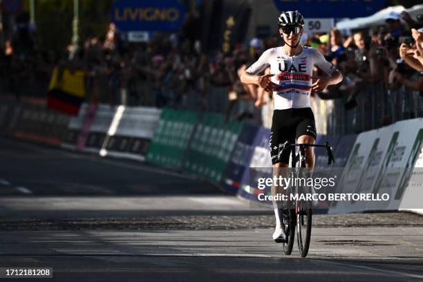 Team Emirates team's Slovenian rider Tadej Pogacar celebrates as he crosses the finish line to win the 117th edition of the Giro di Lombardia , a...