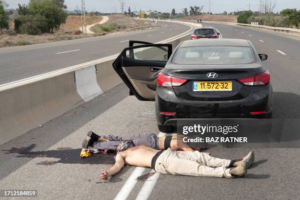 Graphic content / The bodies of civilians killed in a Palestinian militant attack lie on a main road in the southern Israeli city of Sderot on...