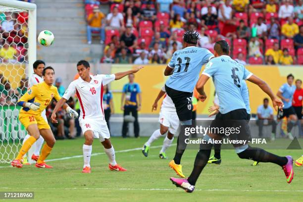 Abel Hernandez of Uruguay hits a header to score a goal in the 2nd minute against Ricky Aitamai and Gilbert Meriel of Tahiti during the FIFA...