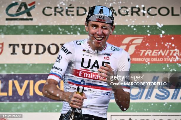 Team Emirates team's Slovenian rider Tadej Pogacar celebrates on the podium after winning the 117th edition of the Giro di Lombardia , a 238km...
