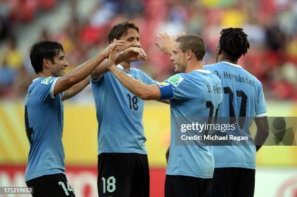 Diego Perez of Uruguay celebrates withe Gaston Ramirez, Nicolas Lodeiro and Abel Hernandez after scoring a goal in the 27th minute against Tahiti...