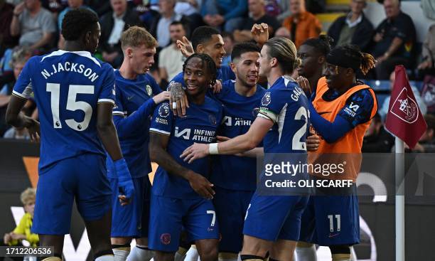 Chelsea's English midfielder Raheem Sterling is mobbed by teammates after scoring the team's third goal during the English Premier League football...