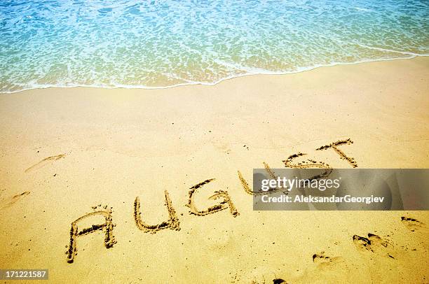 august handwritten in the sandy shoreline - august stock pictures, royalty-free photos & images