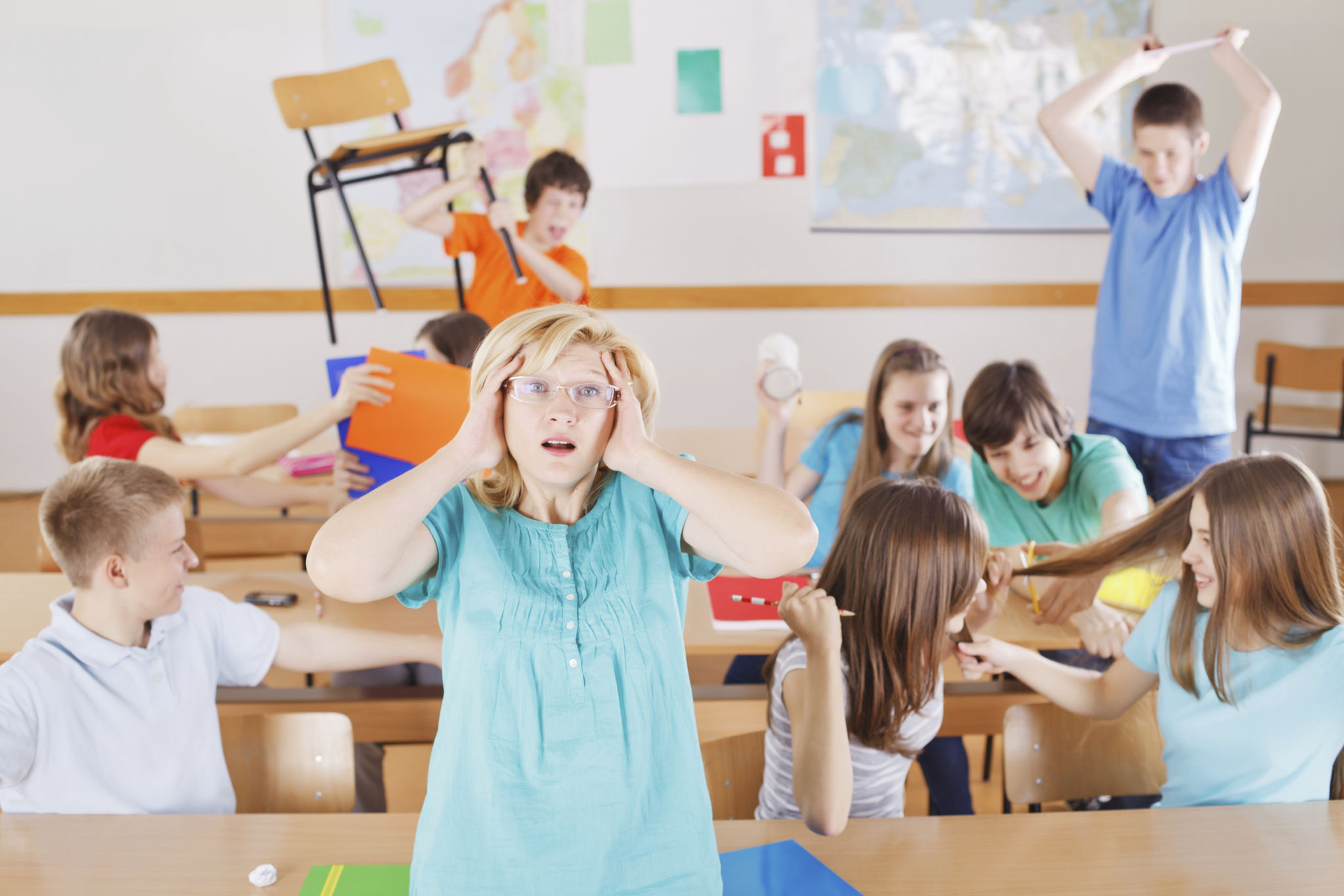Frustrated teacher in classroom, pupils behind her behave bad. Frustrated teacher in classroom, pupils behind her behave bad.