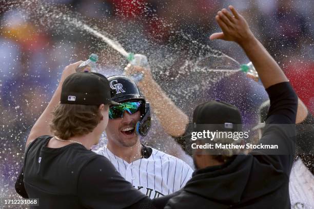 Brenton Doyle of the Colorado Rockies celebrates with his teammates after scoring the winning run against the Minnesota Twins in the eleventh inning...