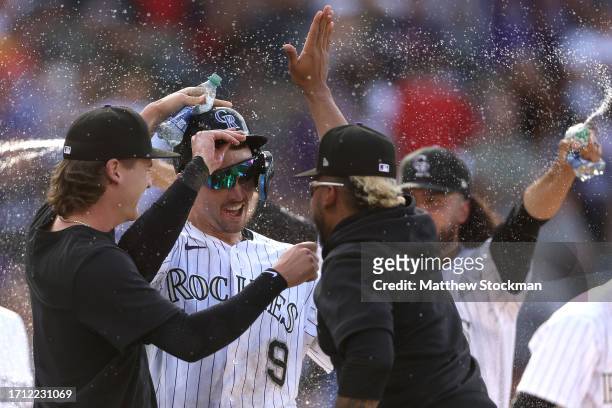 Brenton Doyle of the Colorado Rockies celebrates with his teammates after scoring the winning run against the Minnesota Twins in the eleventh inning...