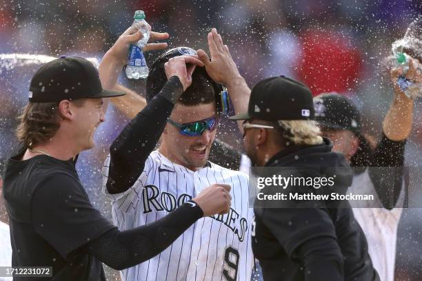 Brenton Doyle of the Colorado Rockies celebrates with his teammates after scoring the winning run against the Minnesota Twins in the eleventh inning...