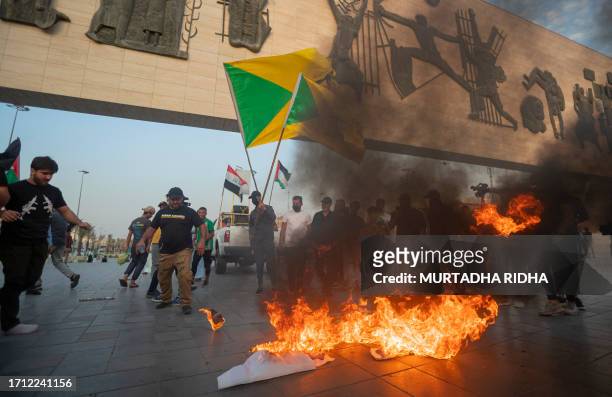 Iraqis burn Israeli flags during a rally held in central Baghdad on October 7, 2023 in support of the Palestinians, after Hamas militants launched a...