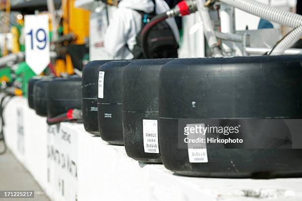 racing tires on pit wall - course de stock cars stockfoto's en -beelden