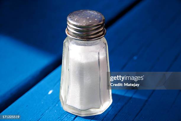 salt shaker auf blau - gesalzenes stock-fotos und bilder