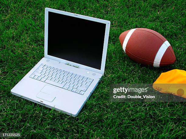 fantasy football concept: laptop computer and football on grass field - fantasy football stock pictures, royalty-free photos & images