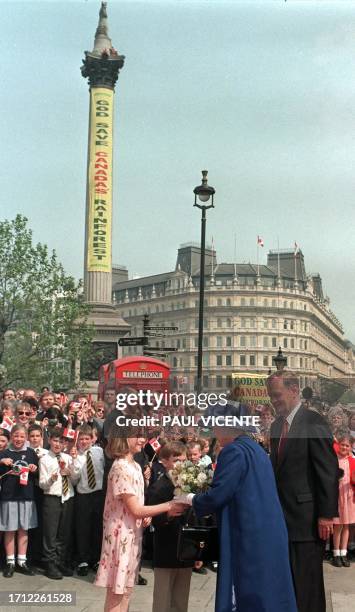 Britain's Queen Elizabeth 2, smiles as she receives flowers from children, 13 May watched by Canadian Prime Minister Jean Cretien as she arrives to...