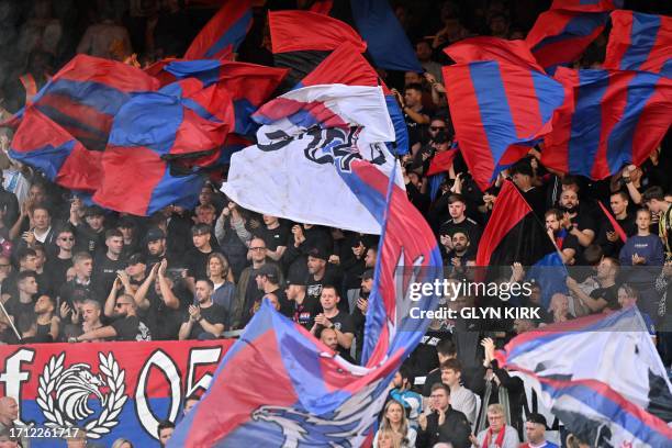 Palace fans wave flags in the crowd ahead of the English Premier League football match between Crystal Palace and Nottingham Forest at Selhurst Park...