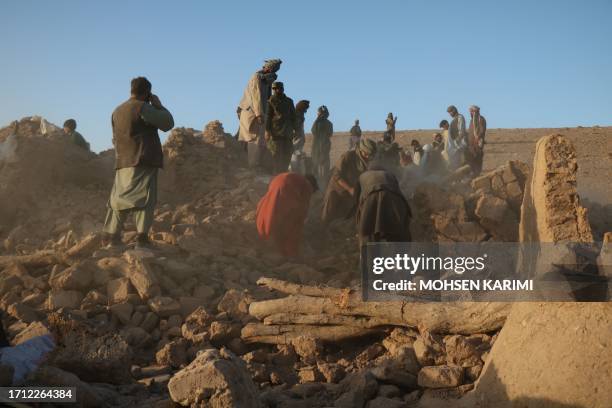 Afghan residents clear debris from a damaged house after earthquake in Sarbuland village of Zendeh Jan district of Herat province on October 7,2023