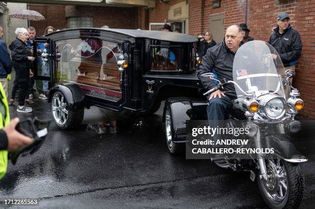 Auman funeral home employees and volunteers load the casket of 'Stoneman Willie' , during his funeral service in Reading, Pennsylvania, on October 7,...
