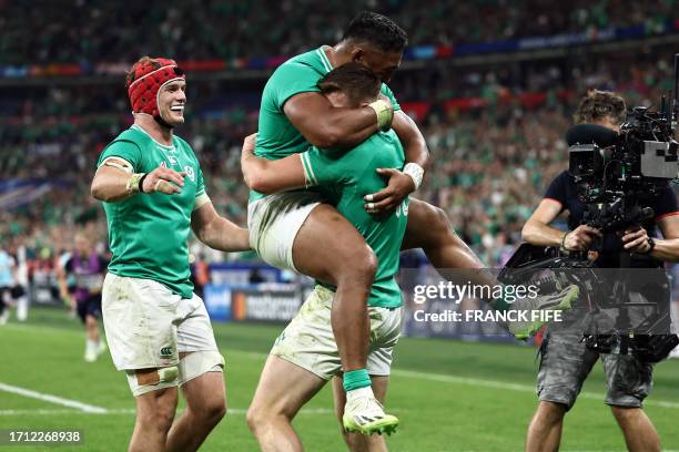 Ireland's centre Garry Ringrose celebrates with teammates Ireland's centre Bundee Aki and Ireland's flanker Josh van der Flier after scoring a try...