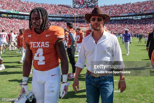 Actor Mathew McConaughey walks off field with Texas Longhorns defensive back Austin Jordan after the game against the Oklahoma Sooners on October...