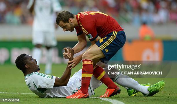 Spain's forward Roberto Soldado helps Nigeria's defender Azubuike Egwuekwe to stand up after they both fall during their FIFA Confederations Cup...