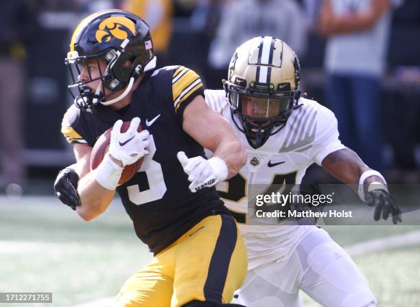 Defensive back Cooper DeJean of the Iowa Hawkeyes is tackled during the first half by defensive back Anthony Brown of the Purdue Boilermakers at...