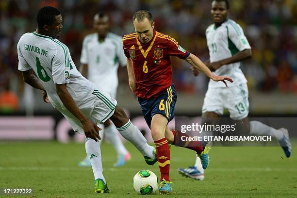 Spain's midfielder Andres Iniesta is marked by Nigeria's defender Azubuike Egwuekwe during their FIFA Confederations Cup Brazil 2013 Group B football...
