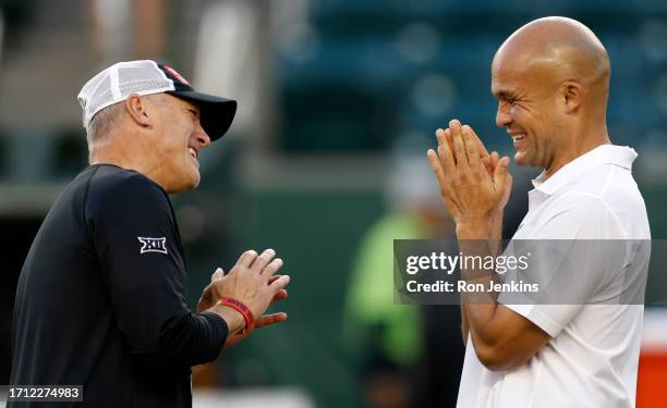 Head coach Joey McGuire of the Texas Tech Red Raiders and head coach Dave Aranda of the Baylor Bears share a laugh on the field before their game at...