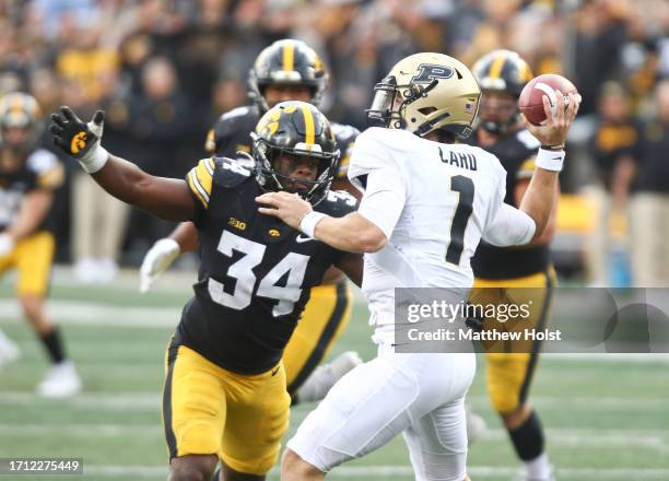 Quarterback Hudson Card of the Purdue Boilermakers throws during the second half under pressure from linebacker Jay Higgins of the Iowa Hawkeyes at...