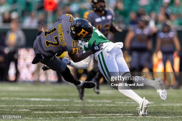 Terry Godwin II of the Hamilton Tiger-Cats is knocked of his feet by Deontai Williams of the Saskatchewan Roughriders after making a catch in the...