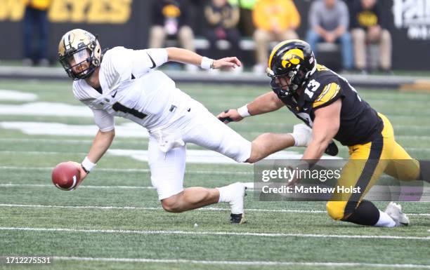 Quarterback Hudson Card of the Purdue Boilermakers throws the ball away during the first half under pressure from defensive end Joe Evans of the Iowa...
