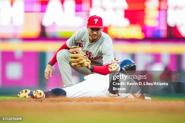 Trea Turner of the Philadelphia Phillies tags out Ozzie Albies of the Atlanta Braves during Game One of the National League Division Series baseball...