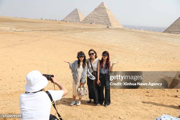 Chinese tourists pose for photos while visiting the Giza Pyramids in Giza, Egypt, Oct. 4, 2023. TO GO WITH "Feature: Chinese outbound tourists key to...