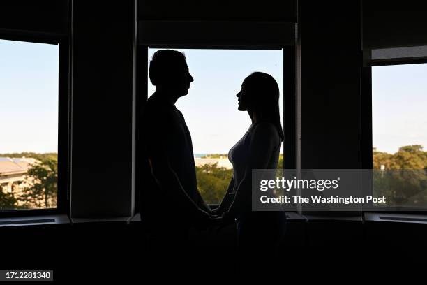 Migrant couple who did not want to be identified is silhouetted in a window as they poses for a portrait at the National Immigrant Justice Center on...