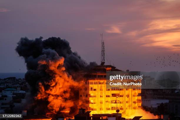 Smoke rises and ball of fire over a buildings in Gaza City on October 7, 2023 during an Israeli air strike. Medical sources in Gaza say at least 198...