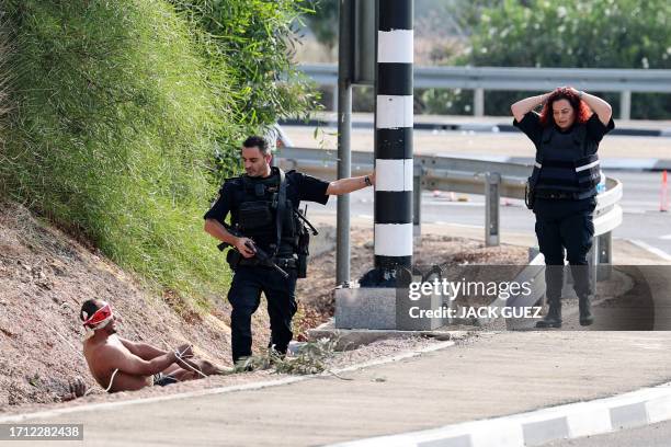 Graphic content / A blind-folded Palestinian prisoner speaks to a member of the Israeli security forces on the border with Gaza near the southern...