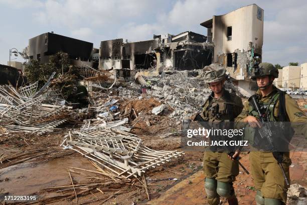 Soldiers walk in front of an Israeli police station that was damaged during battles to dislodge Hamas militants who were stationed inside, on October...